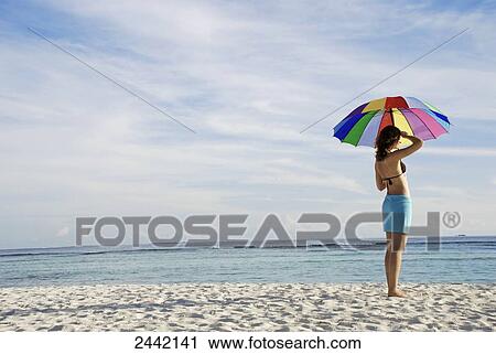 Woman holding umbrella on beach View Large Photo Image Stock Image - Woman holding umbrella on beach . Fotosearch