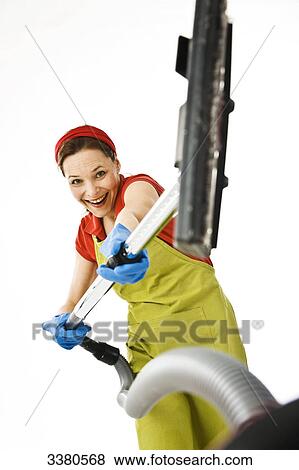 Stock Photo - Woman holding vacuum cleaner . Fotosearch