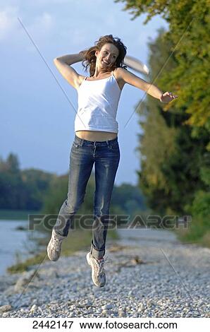 Stock Photo - Woman jumping on beach . Fotosearch
