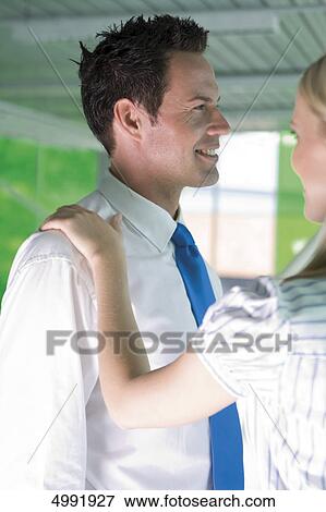 Woman laying hand on the shoulder of smiling businessman View Large Photo Image Stock Photo - Woman laying hand on the shoulder of smiling businessman . Fotosearch
