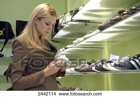 Woman looking at shoes in shop View Large Photo Image Picture - Woman looking at shoes in shop . Fotosearch