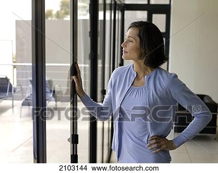 Picture - Woman looking through window . Fotosearch