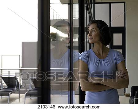 Stock Photograph - Woman looking through window . Fotosearch
