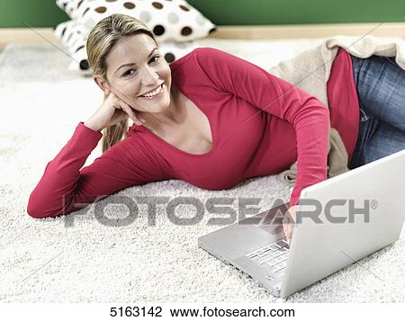 Woman lying in front of laptop View Large Photo Image Stock Image - Woman lying in front of laptop . Fotosearch
