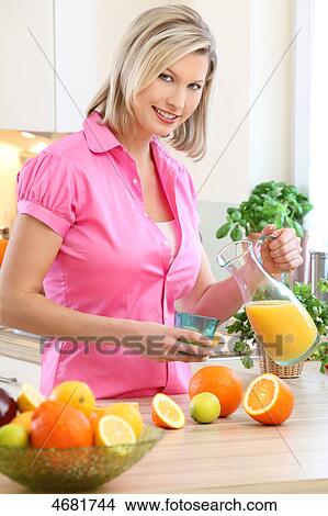 Woman pouring orange juice View Large Photo Image Picture - Woman pouring orange juice . Fotosearch