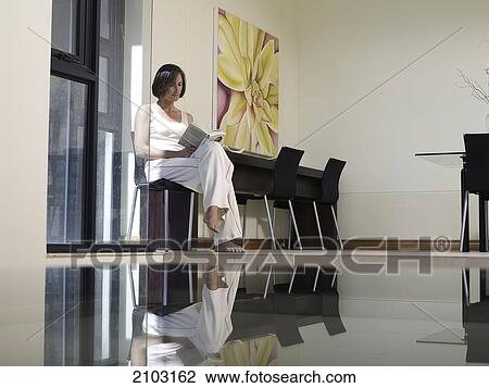 Woman reading book on chair View Large Photo Image Stock Image - Woman reading book on chair . Fotosearch