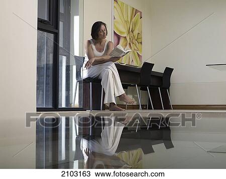 Woman reading book on chair View Large Photo Image Stock Image - Woman reading book on chair . Fotosearch