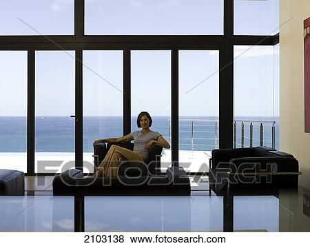 Woman sitting in armchair View Large Photo Image Stock Photo - Woman sitting in armchair . Fotosearch