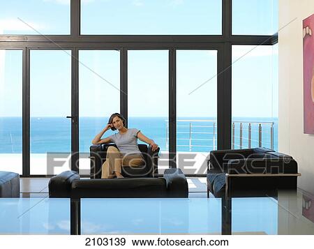 Stock Photo - Woman sitting in armchair . Fotosearch