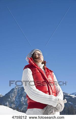 Woman standing with eyes closed in winter landscape, Tannheimer Tal, Tyrol, Austria View Large Photo Image Stock Image - Woman standing with eyes closed in winter landscape, Tannheimer Tal, Tyrol, Austria . Fotosearch