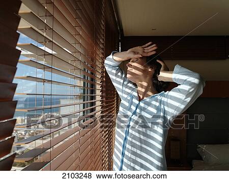 Woman standing with eyes closed near window View Large Photo Image Stock Photo - Woman standing with eyes closed near window . Fotosearch