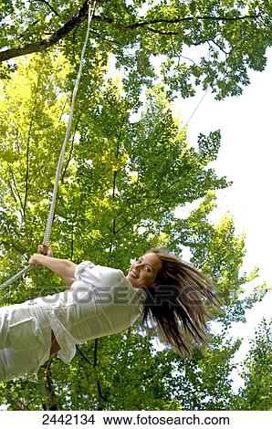 Woman swinging on rope and smiling View Large Photo Image Picture - Woman swinging on rope and smiling . Fotosearch