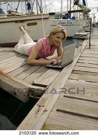 Woman using laptop at harbor View Large Photo Image Stock Image - Woman using laptop at harbor . Fotosearch