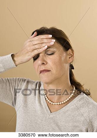 Stock Image - Woman with hand on forehead . Fotosearch