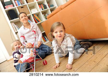 Woman with her two daughters in living room View Large Photo Image Picture - Woman with her two daughters in living room . Fotosearch