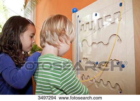 Picture - Young boy and girl playing in a kindergarten, low angle view . Fotosearch