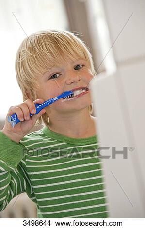 Young boy brushing his teeth, low angle view View Large Photo Image Picture - Young boy brushing his teeth, low angle view . Fotosearch