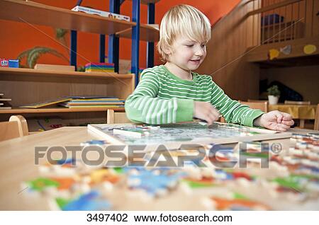 Young boy doing a jigsaw, low angle view View Large Photo Image Stock Image - Young boy doing a jigsaw, low angle view . Fotosearch