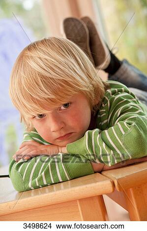 Picture - Young boy lying on a table . Fotosearch
