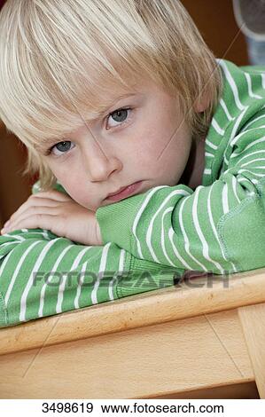Stock Photo - Young boy lying on a table, portrait . Fotosearch