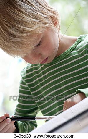 Young boy painting, low angle view View Large Photo Image Stock Photo - Young boy painting, low angle view . Fotosearch