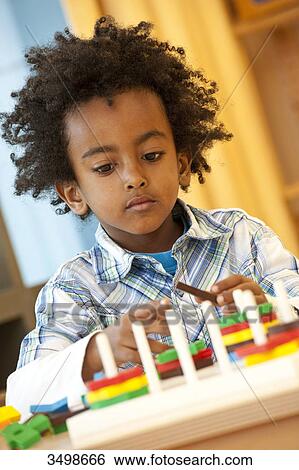 Young boy playing with toys, portrait View Large Photo Image Stock Photograph - Young boy playing with toys, portrait . Fotosearch