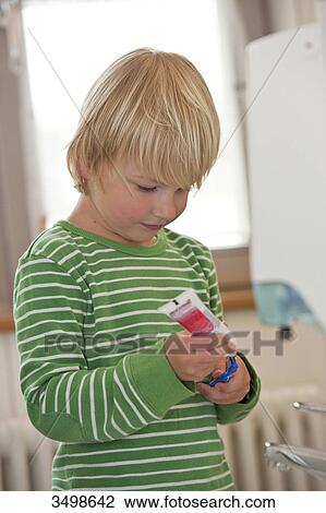 Young boy putting toothpaste on a toothbrush View Large Photo Image Stock Image - Young boy putting toothpaste on a toothbrush . Fotosearch