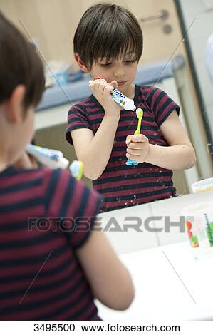 Young boy putting toothpaste on his toothbrush View Large Photo Image Stock Image - Young boy putting toothpaste on his toothbrush . Fotosearch