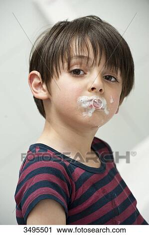 Stock Image - Young boy with toothpaste in his face, portrait . Fotosearch