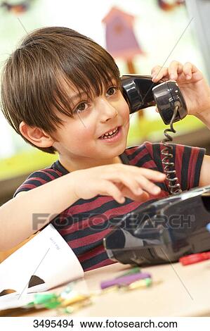 Young boy with toy phone, low angle view View Large Photo Image Picture - Young boy with toy phone, low angle view . Fotosearch