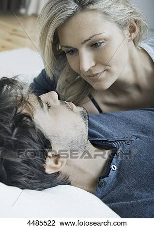 Young couple in bed looking at each other View Large Photo Image Stock Image - Young couple in bed looking at each other . Fotosearch