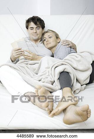 Young couple in bed reading book View Large Photo Image Stock Photo - Young couple in bed reading book . Fotosearch