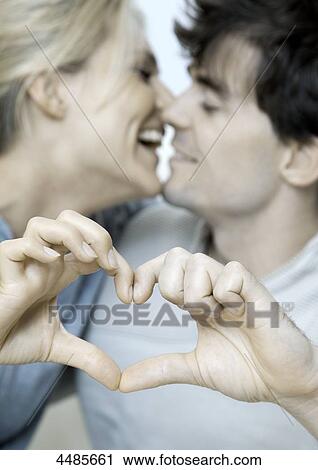 Young couple in love making heart with their hands View Large Photo Image Stock Image - Young couple in love making heart with their hands . Fotosearch