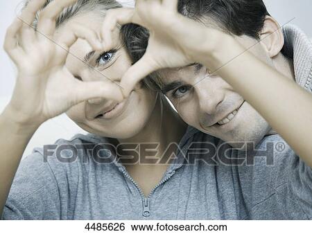 Young couple in love making heart with their hands View Large Photo Image Stock Photograph - Young couple in love making heart with their hands . Fotosearch