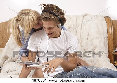 Young couple listening to music in bed View Large Photo Image Stock Image - Young couple listening to music in bed . Fotosearch