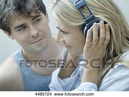 Picture - Young couple listening to music with headphones . Fotosearch