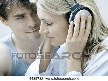 Young couple listening to music with headphones View Large Photo Image Stock Image - Young couple listening to music with headphones . Fotosearch