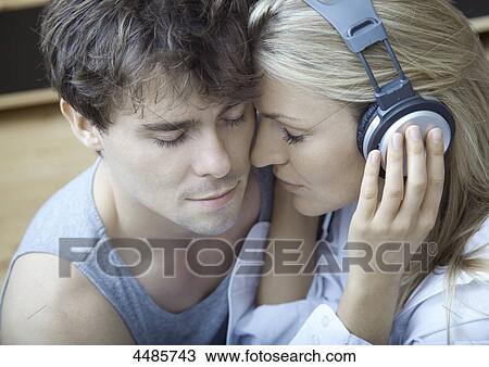 Young couple listening to music with headphones View Large Photo Image Stock Image - Young couple listening to music with headphones . Fotosearch