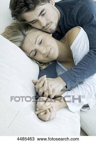 Young couple lying hand in hand in bed View Large Photo Image Stock Image - Young couple lying hand in hand in bed . Fotosearch