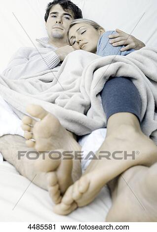 Stock Image - Young couple lying in bed . Fotosearch