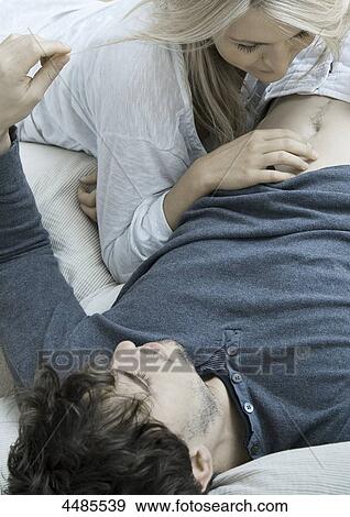 Young couple lying in bed View Large Photo Image Stock Photo - Young couple lying in bed . Fotosearch