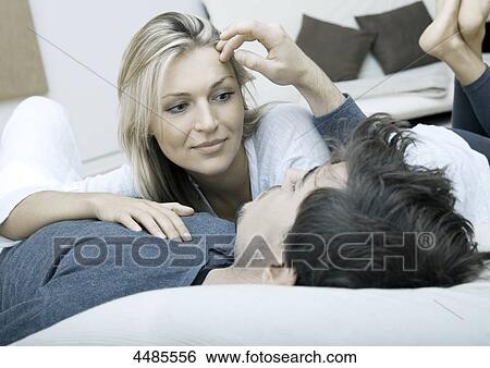 Young couple lying in bed View Large Photo Image Stock Photograph - Young couple lying in bed . Fotosearch