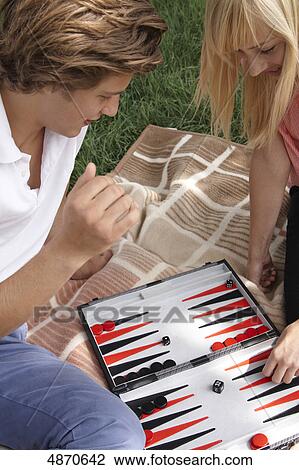 Young couple playing backgammon outdoors View Large Photo Image Stock Image - Young couple playing backgammon outdoors . Fotosearch