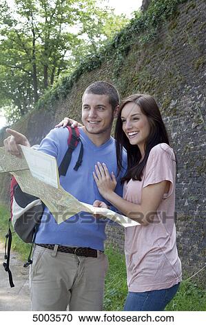 Young couple reading map outdoors View Large Photo Image Stock Image - Young couple reading map outdoors . Fotosearch