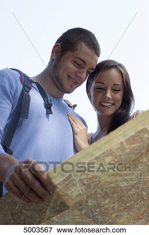 Young couple reading map outdoors View Large Photo Image Stock Photo - Young couple reading map outdoors . Fotosearch