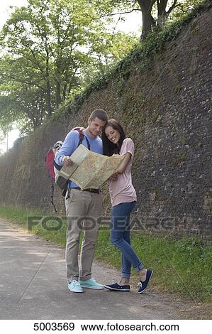 Young couple reading map outdoors View Large Photo Image Stock Photo - Young couple reading map outdoors . Fotosearch
