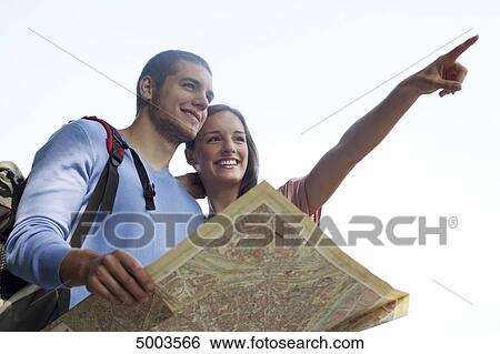 Stock Photograph - Young couple reading map outdoors . Fotosearch
