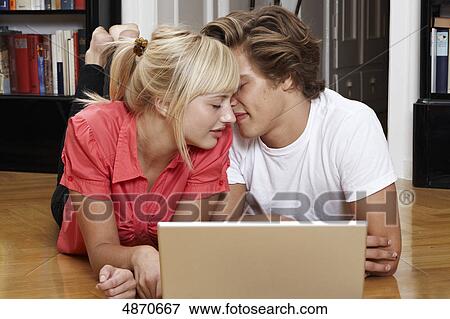 Young couple using laptop on the floor View Large Photo Image Stock Photo - Young couple using laptop on the floor . Fotosearch