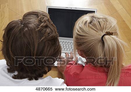 Stock Photography - Young couple using laptop on the floor . Fotosearch