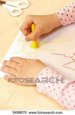 Stock Photography - Young girl drawing a picture with a wax crayon, close-up . Fotosearch